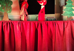 Zdjęcie pacynek liska i baby jagi biorących udział w przedstawieniu.