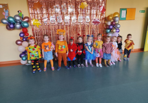 Grupa misie pozująca do zdjęcia na tle napisu bal jesieni.