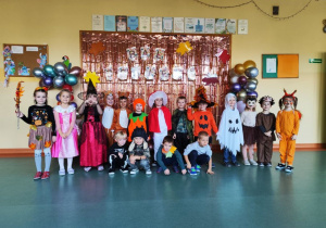 Grupa motylki pozująca do zdjęcia na tle napisu bal jesieni.