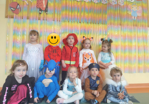 Dzieci z grupy Misie pozujące przy dekoracji z napisem karnawał.