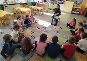 Dzieci z grupy biedronek siedzące na dywanie podczas warsztatów.