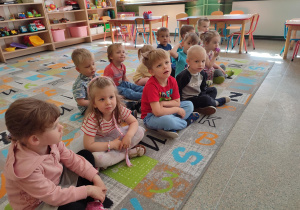 Dzieci z grupy biedronek siedzą na dywanie i słuchają ciekawostek na temat ciekłego azotu.