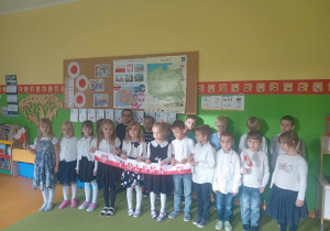 Grupka dzieci stojących na dywanie trzymających flagę Polski