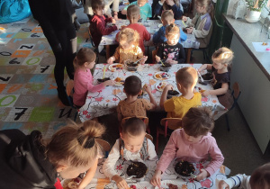 Dzieci z grupy biedronek i misiów siedzące przy stolikach, wykonujące własne herbatki.
