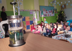 Dzieci siedzące na dywanie słuchające historii na temat herbaty.